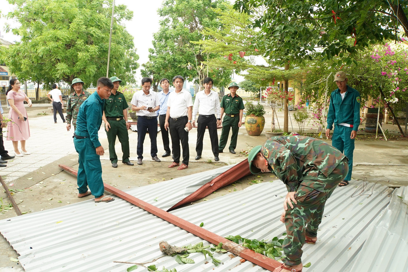 Bí thư Huyện ủy Phú Vang Trần Gia Công (áo trắng, hàng thứ 3) kiểm tra hiện trường, chỉ đạo các lực lượng chức năng khẩn trương khắc phục hậu quả giông lốc tại Trường tiểu học Phú Lương 1.