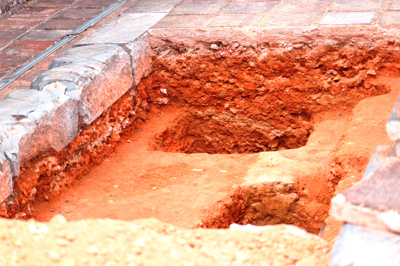 Một vị trí khai quật trên nền móng ngôi điện cổ. (Ảnh: Ngọc Văn)