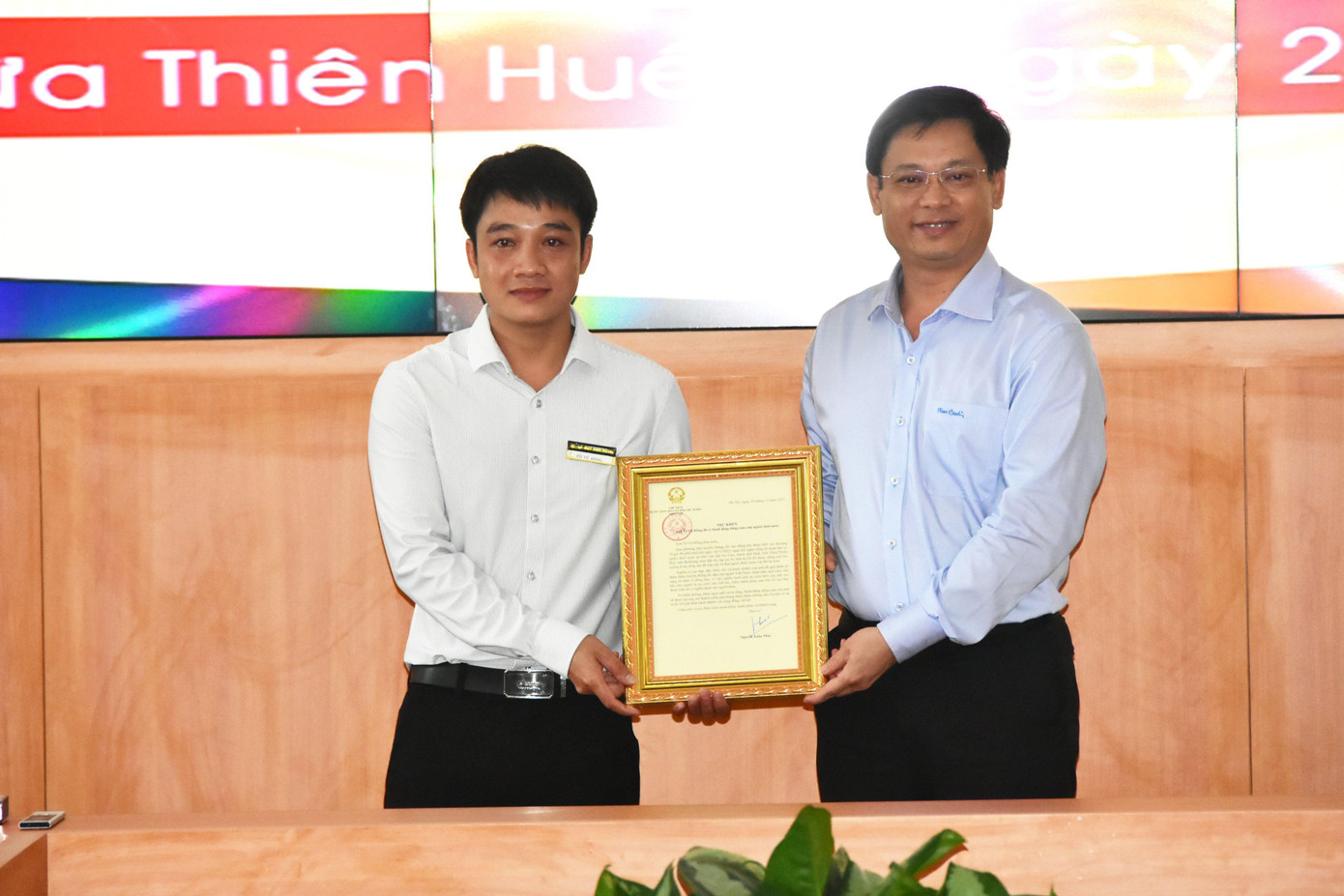 Phó Chủ tịch Thường trực UBND tỉnh TT-Huế Nguyễn Thanh Bình trao Thư khen của Chủ tịch nước cho anh Tô Vũ Đồng (bìa trái).