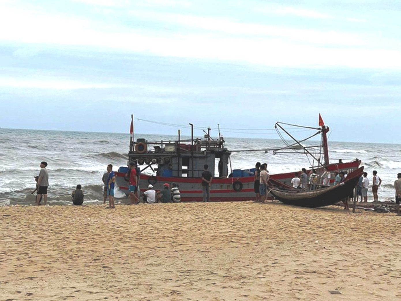 Một tàu cá bị lốc đánh dạt lên bãi biển. Ảnh: CTV