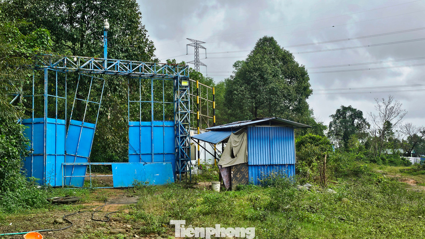 Cổng vào khu dự án nghiêng ngả xiêu vẹo. Nơi đây hiện chỉ có một vài bảo vệ là người địa phương được hợp đồng để trông coi các công trình, bảo vệ tài sản bên trong.