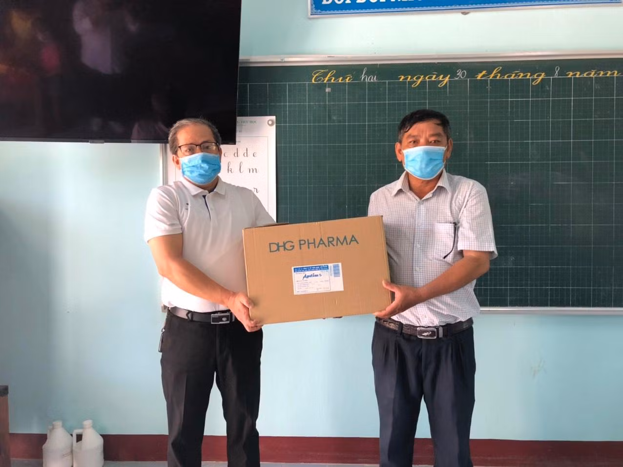 PV thường trú Báo Tiền Phong tại Huế (bìa trái) tặng khẩu trang y tế cho Trường Tiểu học Phong Chương