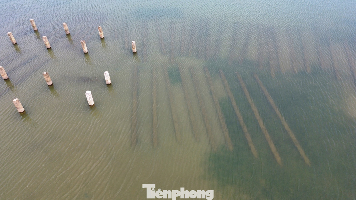 Ngoài những chiếc "gai" bê tông đã được cắm sâu vào lòng đất, dưới đáy đầm còn có nhiều dãy trụ bê tông bị vứt bỏ nằm ngổn ngang có thể trông thấy qua làn nước trong