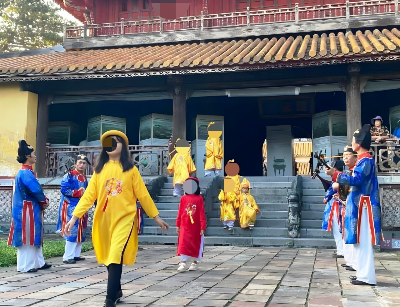 Các em nhỏ mặc trang phục màu vàng khi tham quan ở chốn tôn nghiêm thuộc Đại nội Huế được cho là phản cảm, thiếu phù hợp. Ảnh: MXH.