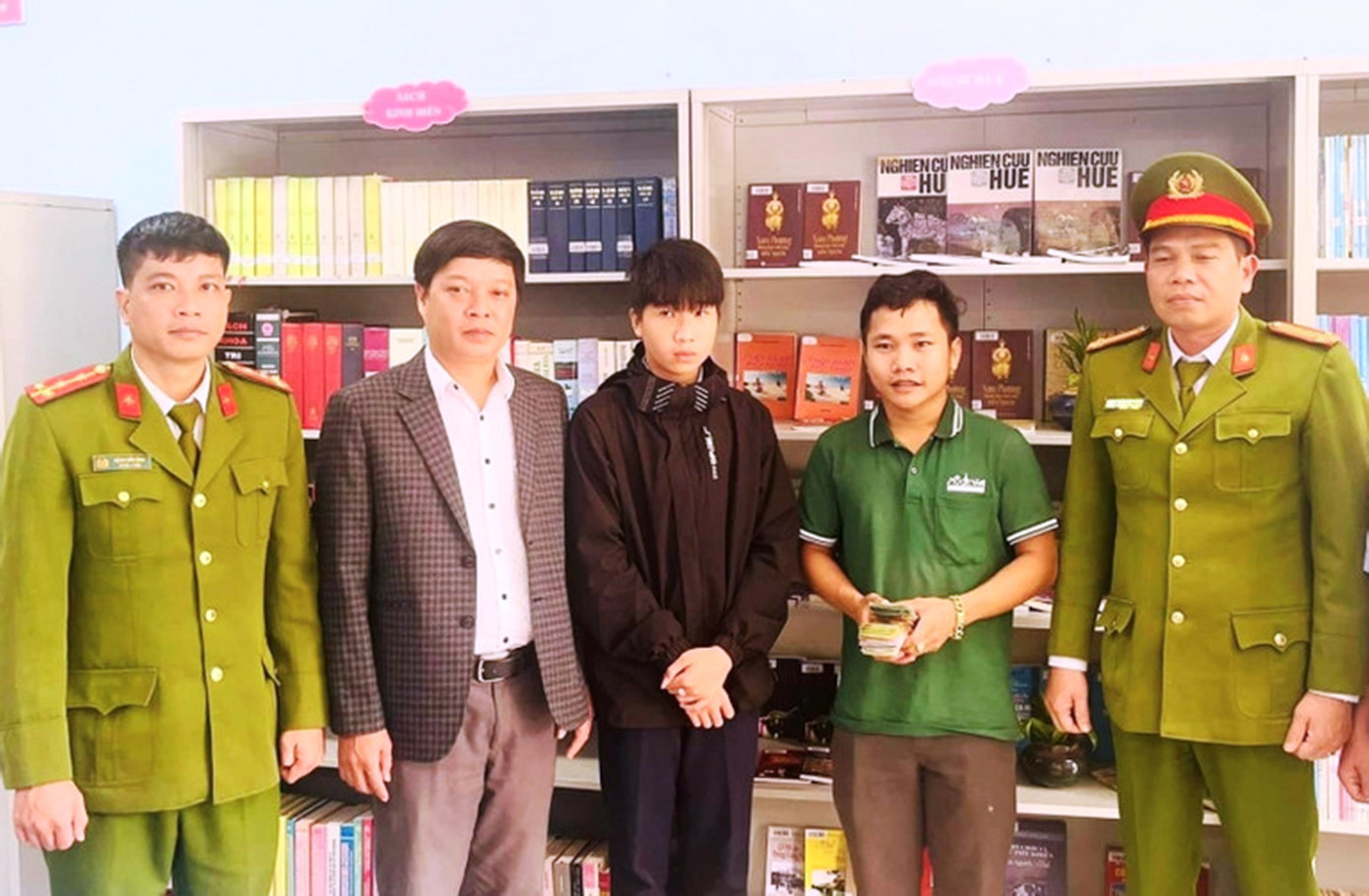 Em Tô Khánh Hoàng Phúc (giữa) cùng đại diện nhà trường, cơ quan công an địa phương trao trả số tiền nhặt được cho nhân viên giao hàng tại Huế. Ảnh: CTV