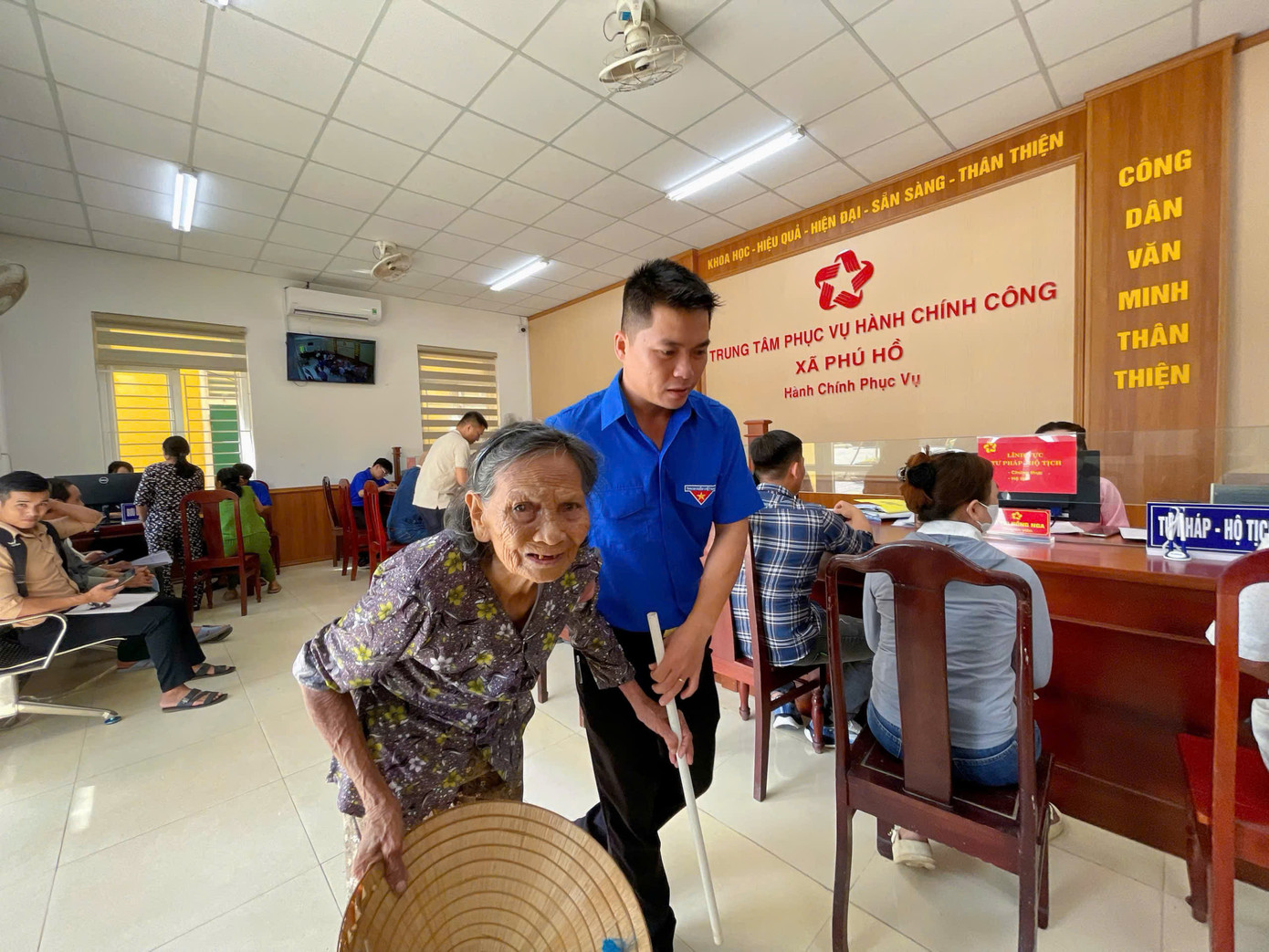 Hỗ trợ người lớn tuổi đi lại khó khăn khi đến xử lý các thủ tục hành chính tại phường.