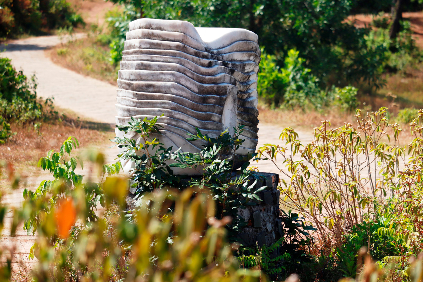 Tượng đá loang lổ rêu phong, bị cỏ dại bao phủ.