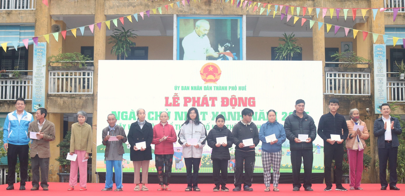 Phó Chủ tịch UBND thành phố Huế Hoàng Hải Minh (ngoài cùng bên phải) tặng quà Tết cho các hộ nghèo trên địa bàn quận Phú Xuân.