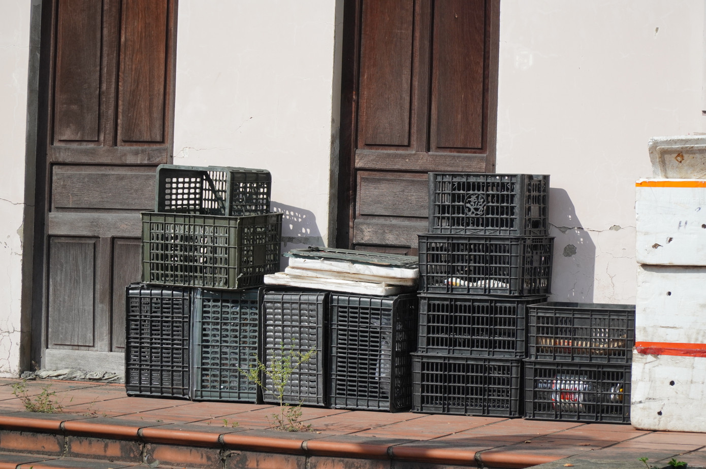 Một vài người dân tận dụng khu nhà Trung tâm bị bỏ hoang để làm nơi tập kết nhiều thùng nhựa chứa trái cây.