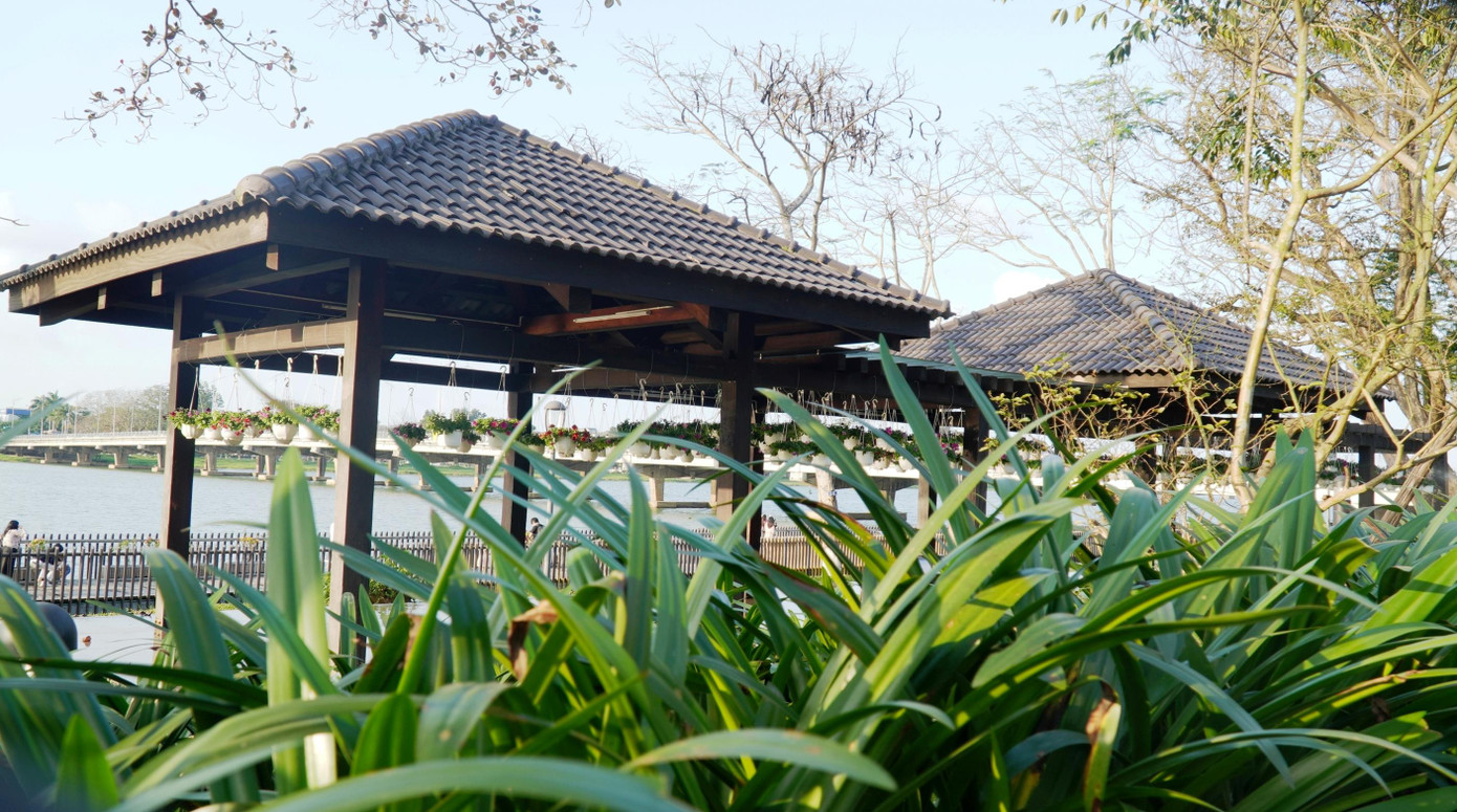 Mướt mát cây lá bao quanh một ngôi nhà là trạm dừng chân cho khách bộ hành cạnh cây cầu gỗ lim sông Hương