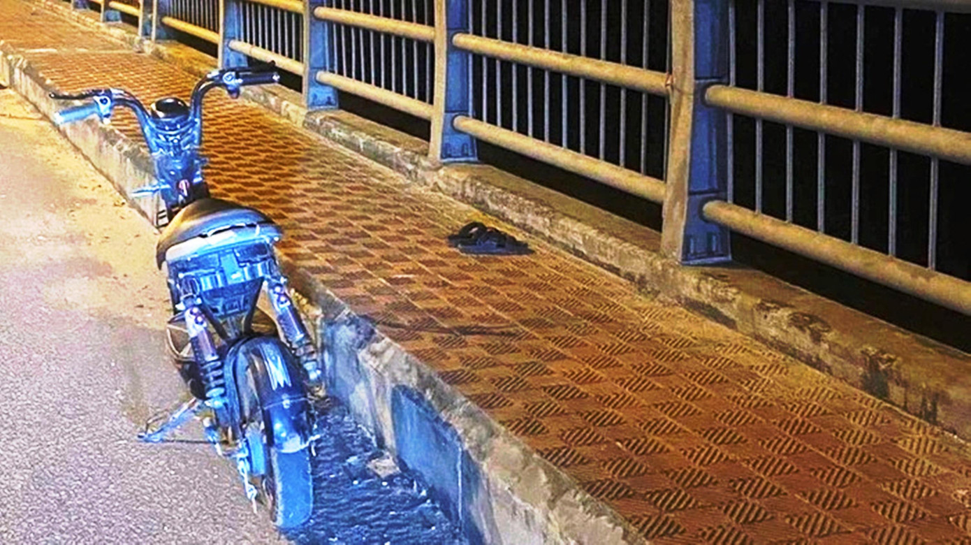 Chiếc xe đạp điện và đôi dép của nữ sinh T. bỏ lại trên cầu. Ảnh CTV Chiếc xe đạp điện và đôi dép của nữ sinh T. bỏ lại trên cầu. Ảnh CTV