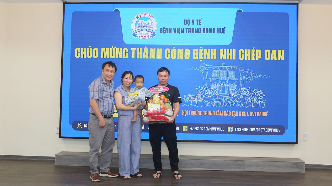 GS.TS Phạm Như Hiệp (bìa trái) tặng quà chúc mừng gia đình cháu bé.