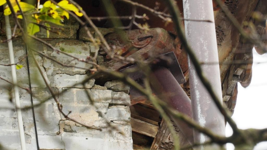 Bờ tường điện bị hỏng, nứt. Cấu kiện gỗ hình đầu rồng được chống đỡ bằng thanh sắt chuyên dụng. Ảnh: Ngọc Văn Bờ tường điện bị hỏng, nứt. Cấu kiện gỗ hình đầu rồng được chống đỡ bằng thanh sắt chuyên dụng. Ảnh: Ngọc Văn