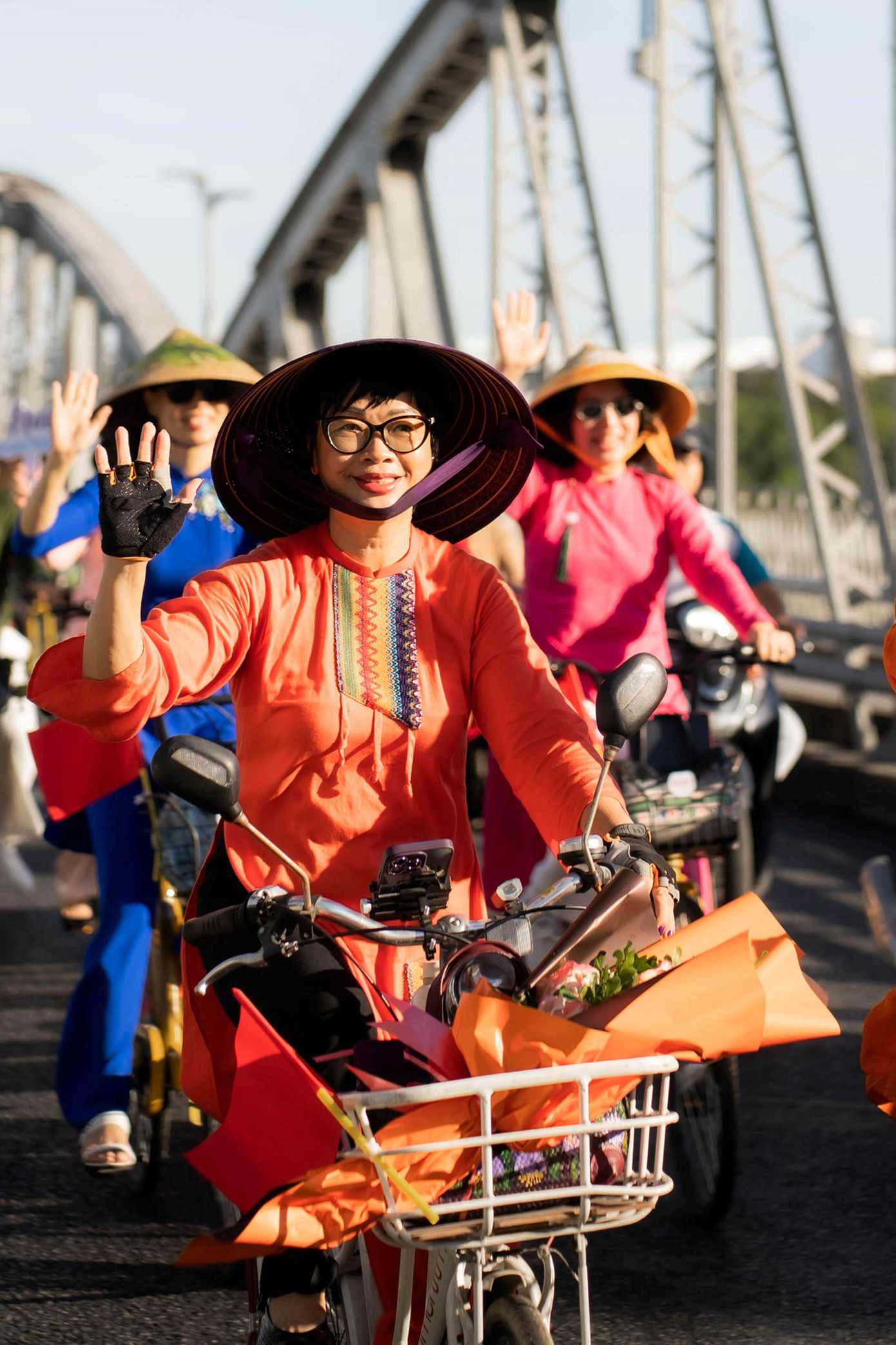 Mang áo dài đạp xe qua cầu Trường Tiền.