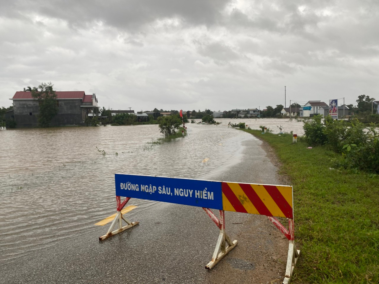 Đặt biển cảnh báo nguy hiểm tại một tuyến đường ngập lụt ở huyện Phong Điền, TT-Huế.