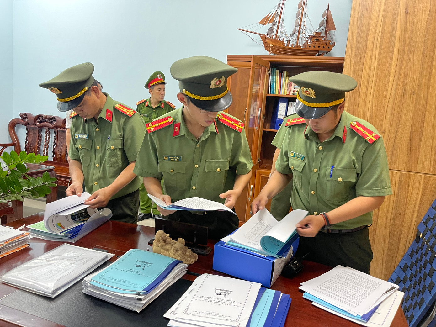 Công an thực hiện khám xét tại nơi làm việc của các đối tượng liên quan.