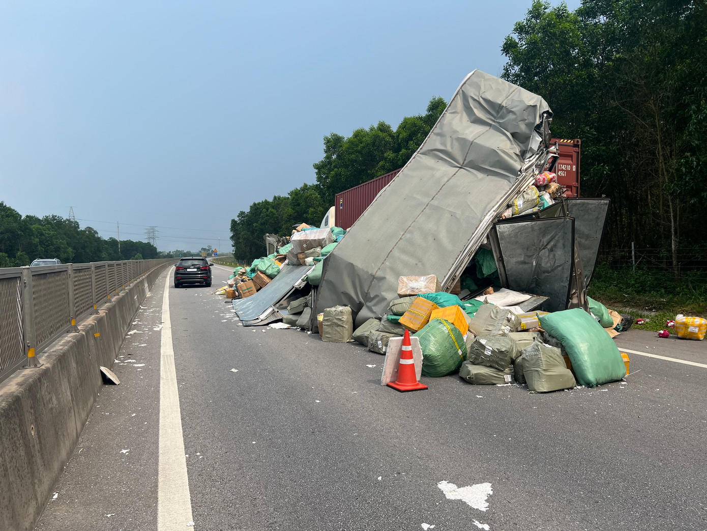 Hàng hóa trên xe tải đổ tràn chiếm một trong hai làn đường cùng chiều tại đoạn tuyến cao tốc có dải phân cách cứng.