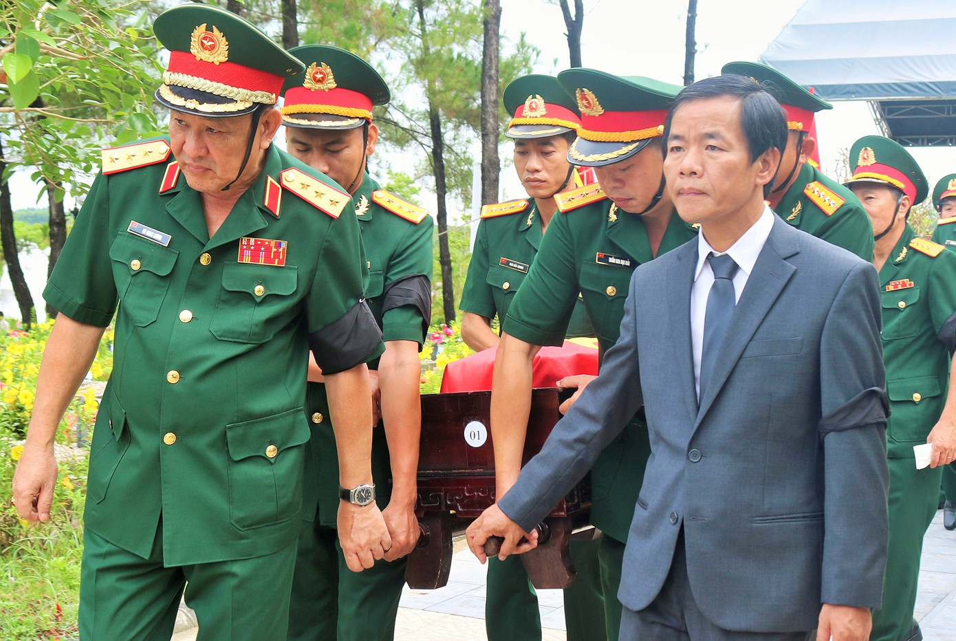 Thực hiện nghi thức an táng hài cốt các anh hùng liệt sĩ. (Ảnh: Minh Nguyên)