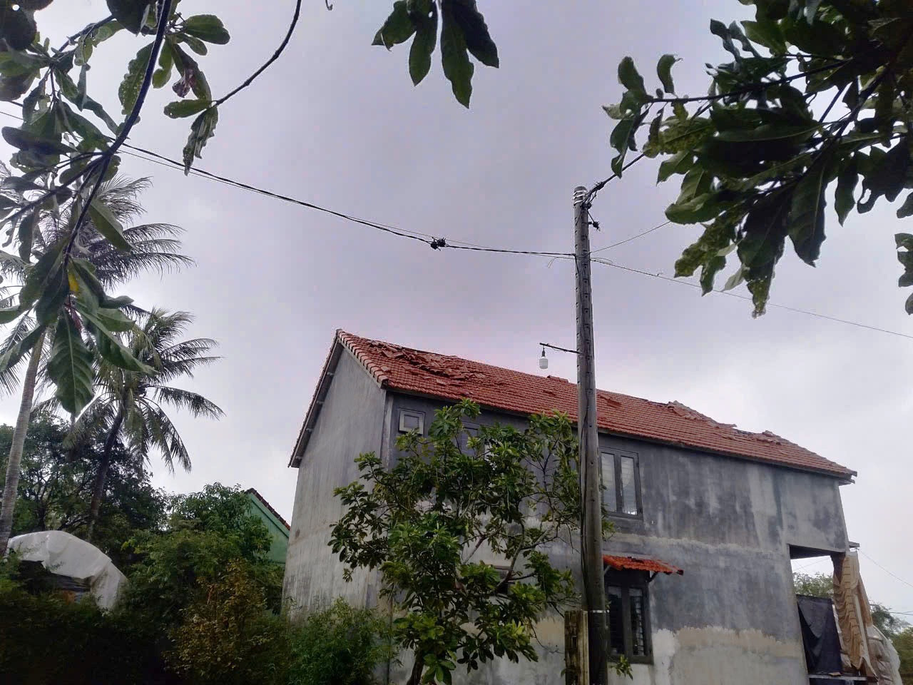 Mái ngói một ngôi nhà dân mới xây bị gió lốc thổi bay từng mảng.