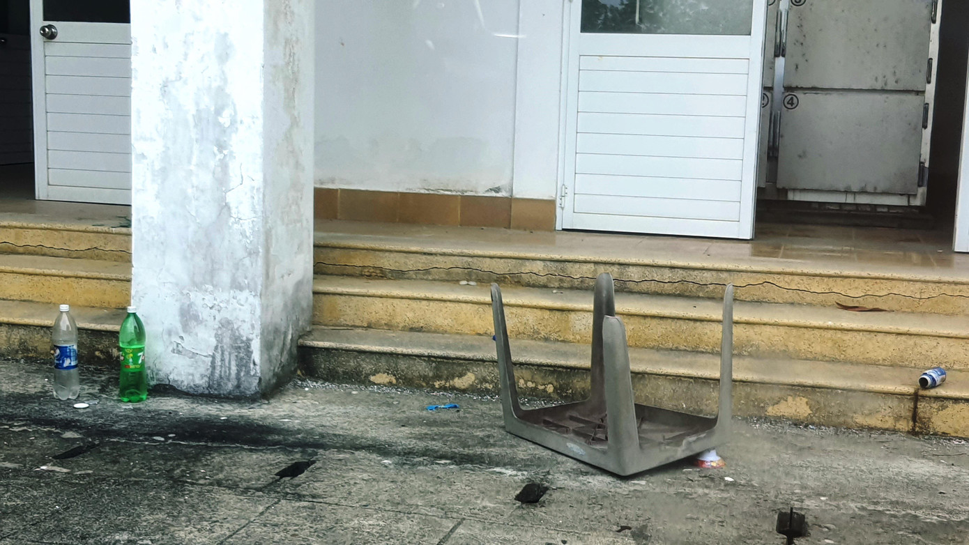 Chai lọ vứt ngổn ngang, bàn ghế nhựa nằm chỏng chơ trước khu nhà đại thể thuộc bệnh viện. Ảnh: N.V