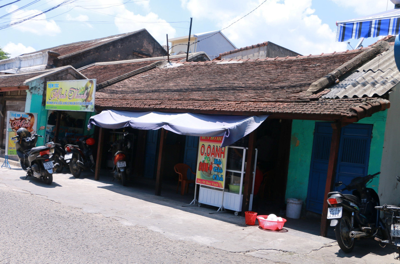 Bên trong những ngôi nhà già nua còn hiện hữu là hàng quán tạp hóa, tiệm cắt tóc, may mặc, ăn uống... Ảnh: Ngọc Văn.