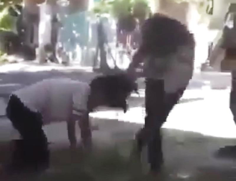 Cháu Đ.T.K.A trong tư thế quỳ bị một bạn nữ túm tóc kéo lê tại một bãi đất trống. Ảnh cắt từ clip Cháu Đ.T.K.A trong tư thế quỳ bị một bạn nữ túm tóc kéo lê tại một bãi đất trống. Ảnh cắt từ clip