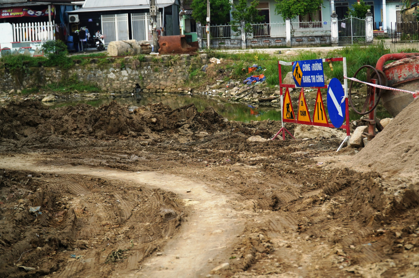 Đường sá đi lại hàng ngày của người dân cạnh công trình cầu trong cảnh bùn lầy.