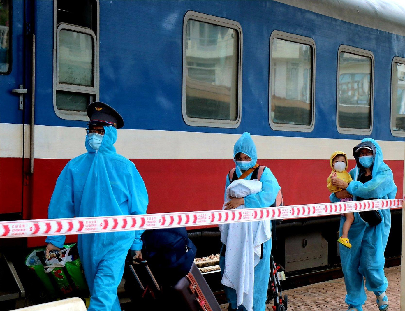 Nhân viên đường sắt hỗ trợ phụ nữ có con nhỏ chuyển hành lý Ảnh: HD