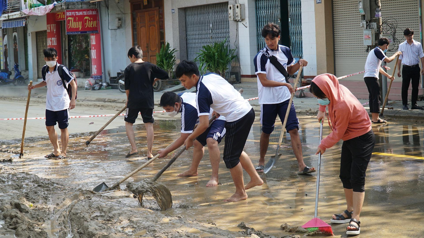Lực lượng sinh viên cùng tham gia dọn bùn, làm sạch phố phường, bảo đảm an toàn giao thông đi lại và mỹ quan đô thị. Ảnh: N.V
