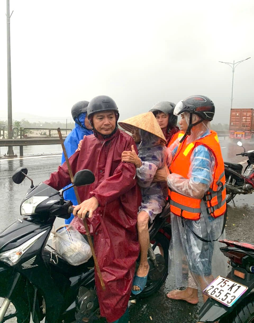 Lực lượng chức năng huyện Phú Lộc dùng xe gắn máy chở người dân từ vùng sạt lở nguy hiểm đến trú tránh ở nơi an toàn.