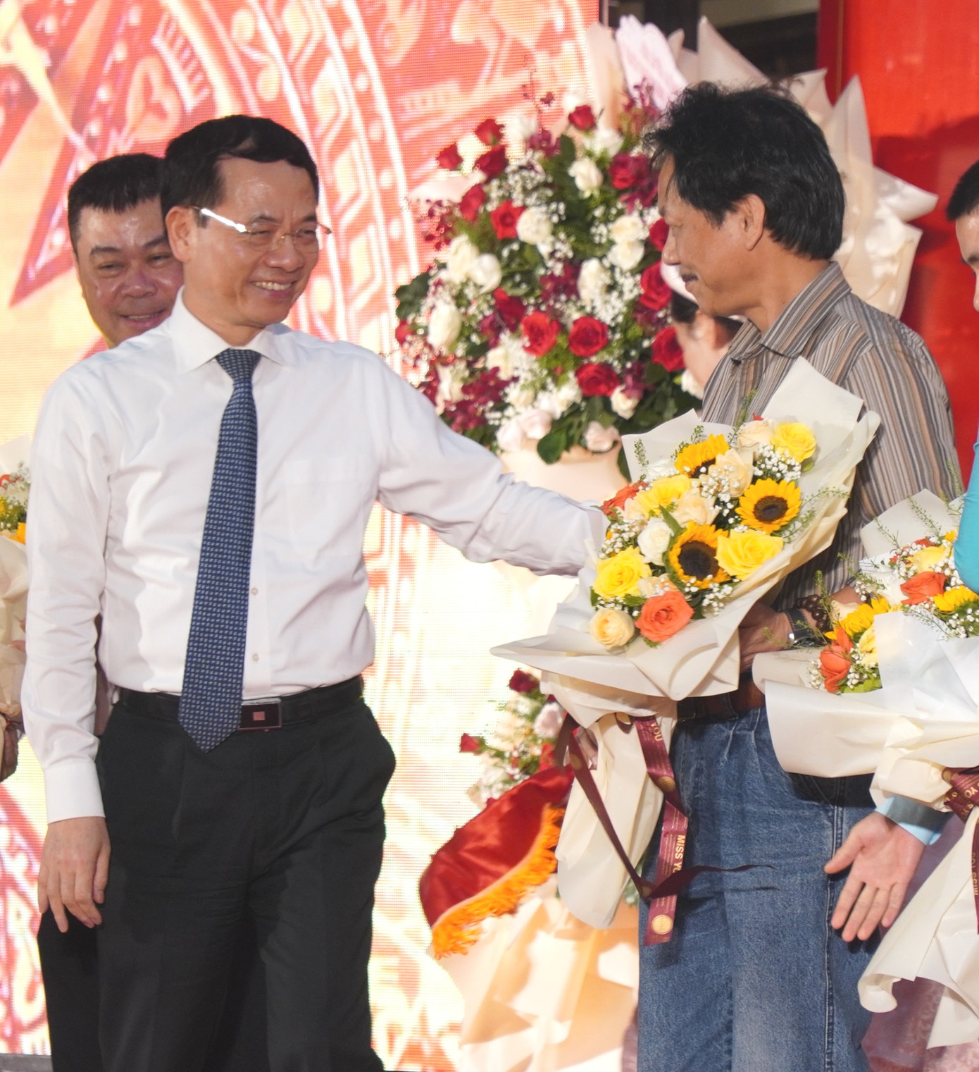 Phó Tổng biên tập Báo Tiền Phong Lê Minh Toản (bìa phải) nhận hoa chúc mừng từ Bộ trưởng Nguyễn Mạnh Hùng. Ảnh: N.V.