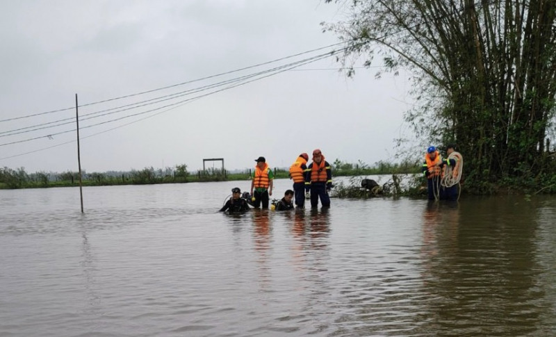 Lực lượng chức năng tổ chức tìm kiếm nạn nhân N.D bị nước cuốn khi di chuyển qua đập tràn ngập lũ. Ảnh: CTV