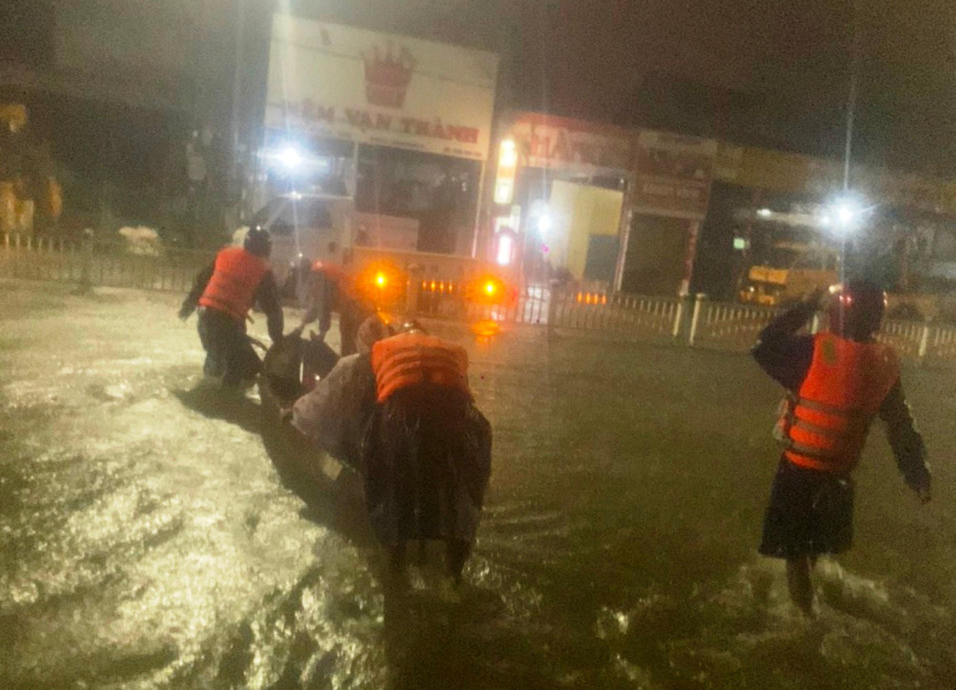 Lực lượng chức năng dùng ghe nhỏ chuyển bệnh nhân suy tim qua vùng lũ dâng cao.