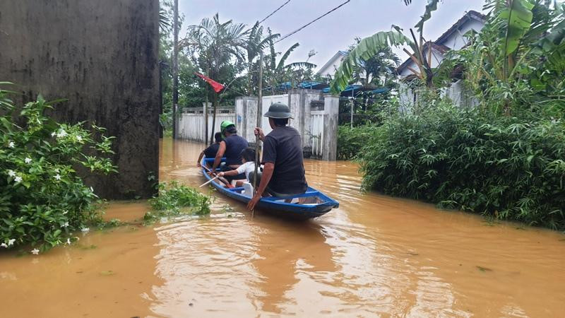 Người dân di chuyển bằng ghe thuyền trên con đường ngập. Ảnh: N.V