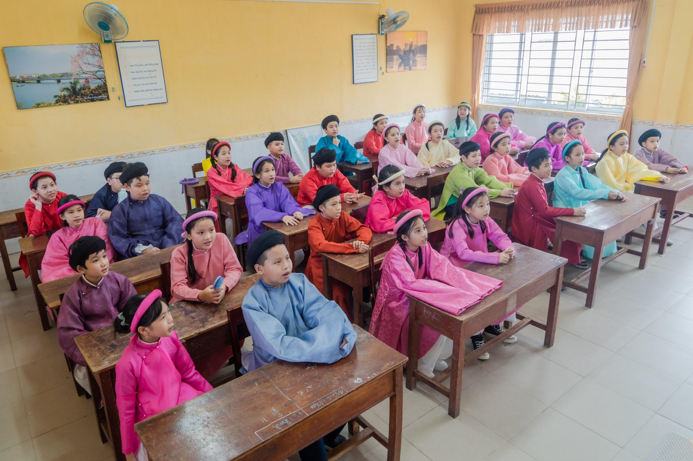 Cô, trò Trường Tiểu học Quang Trung (TP Huế) hào hứng với áo dài truyền thống khi đến lớp. Ảnh Bảo Minh