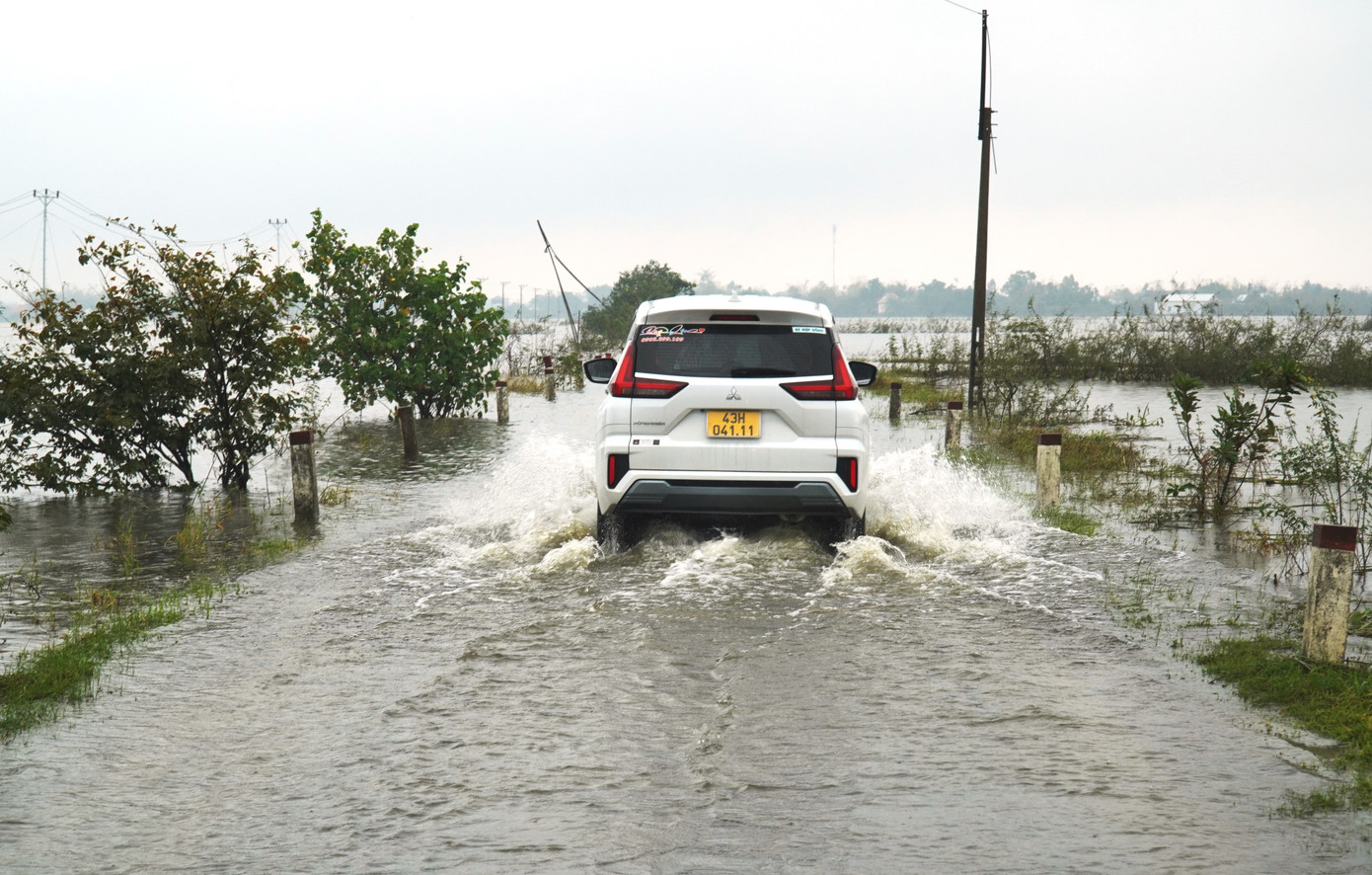 Xe ô tô tìm cách vượt qua đoạn đường ngập lụt tại huyện Phú Vang.