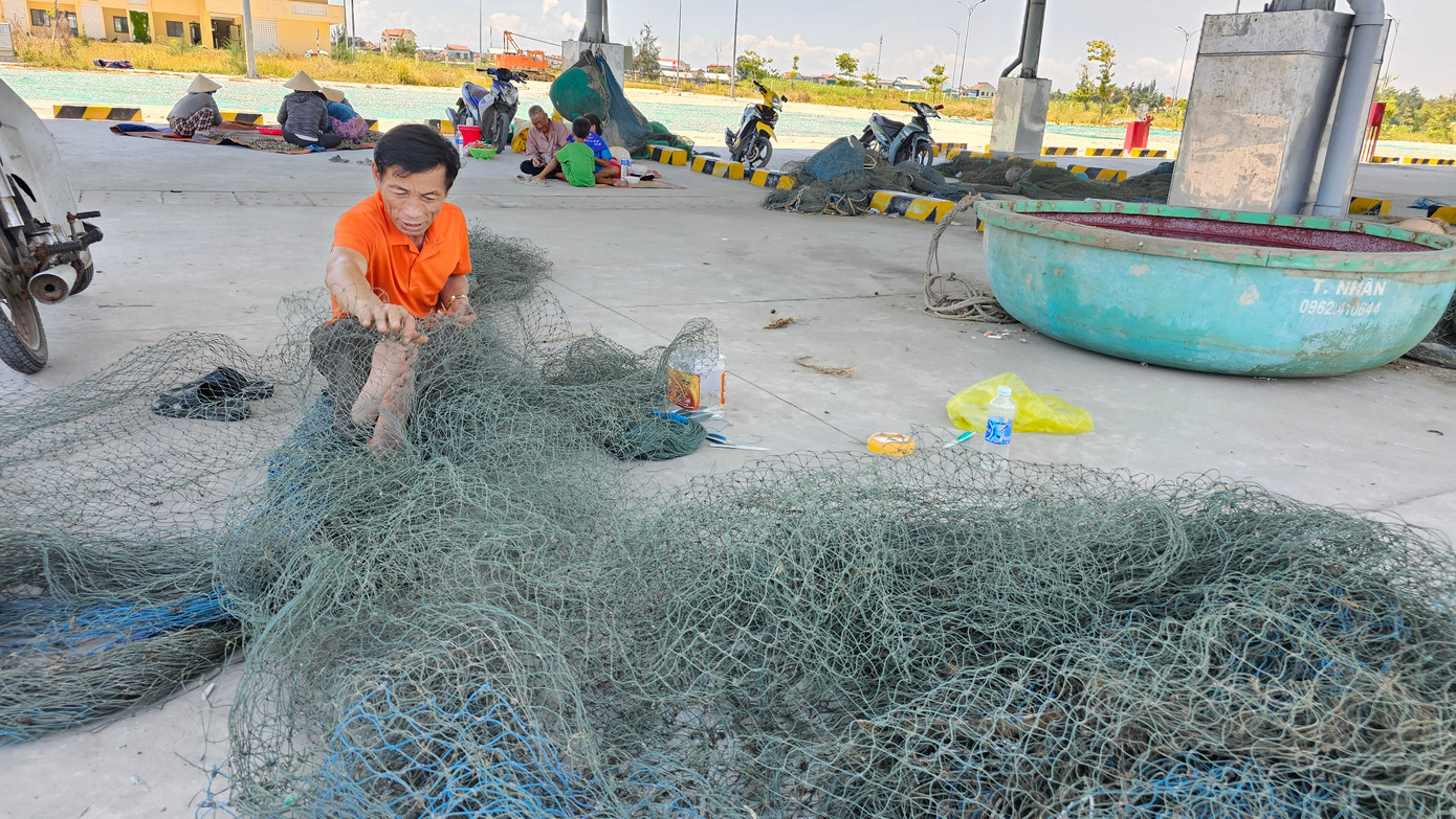 Ngư dân tận dụng khu kho bãi của cảng cá chưa đi vào hoạt động để làm nơi sửa chữa ngư cụ.