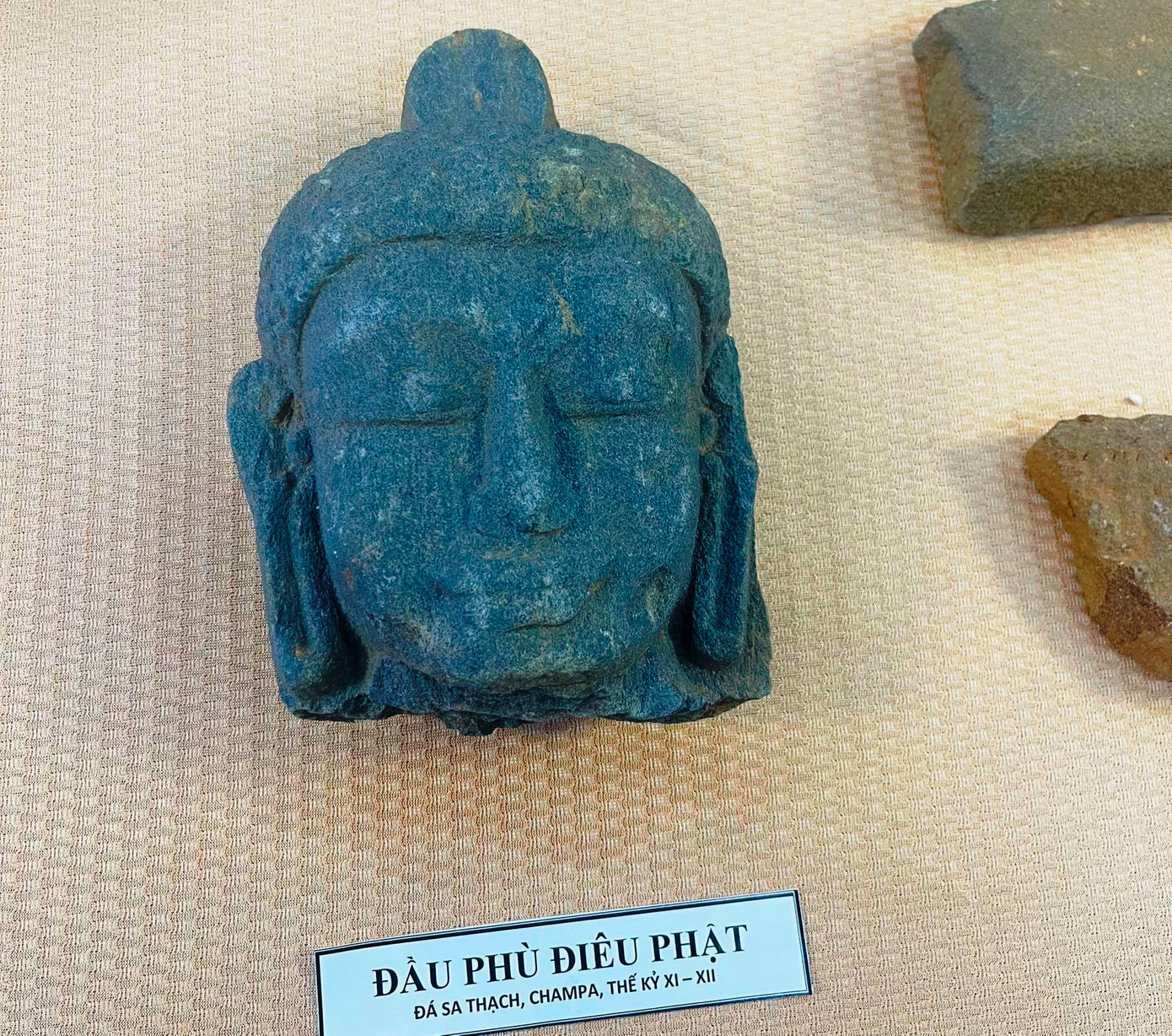 Đầu phù điêu Phật và tiền đồng được tìm thấy tại khu di tích. Đầu phù điêu Phật và tiền đồng được tìm thấy tại khu di tích.