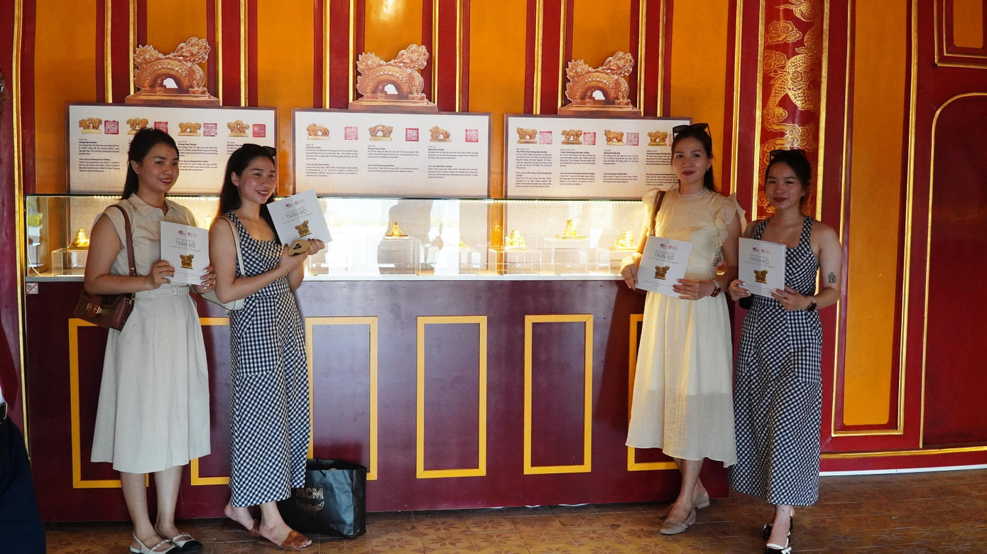 Du khách thích thú chụp ảnh bên phiên bản kim ấn.