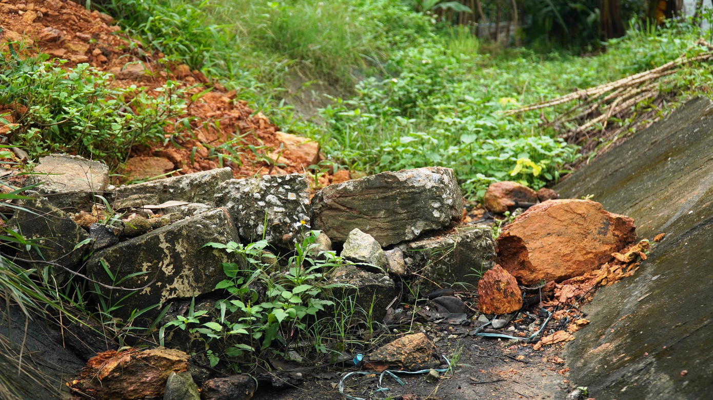 Người dân còn tự ý đổ đất đá xuống hệ thống thoát nước dọc cao tốc để tạo lối đi tự phát băng cắt qua hệ thống hàng rào bị phá dỡ.