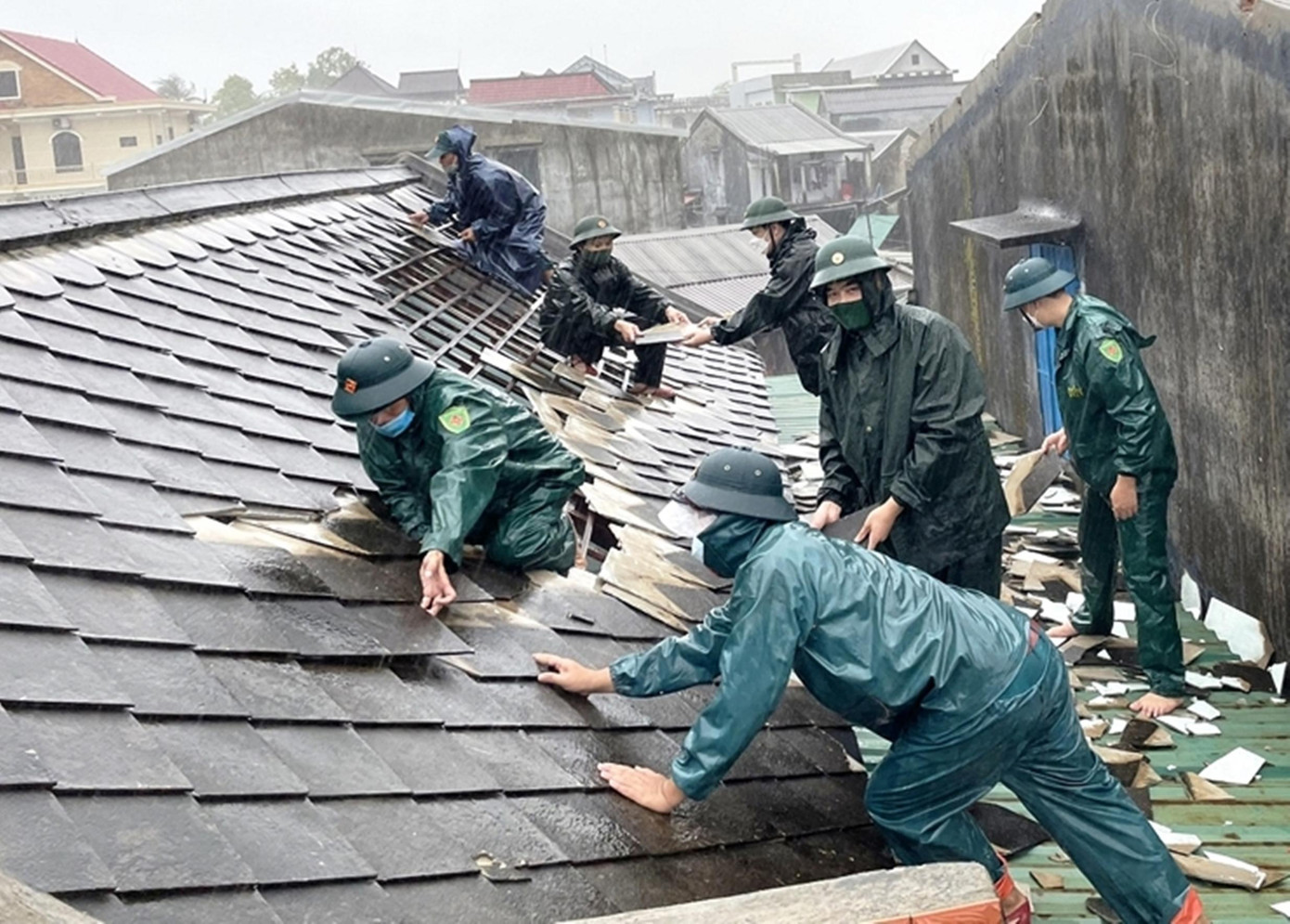 Lực lượng vũ trang hỗ trợ người dân Vinh Hiền (Phú Lộc) lợp lại mái nhà, khắc phục hậu quả lốc lớn. Ảnh: H.C