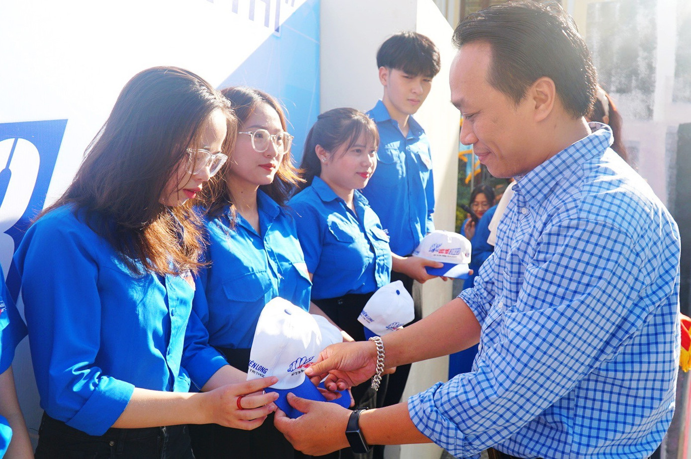 Tặng mũ cho tình nguyện viên.