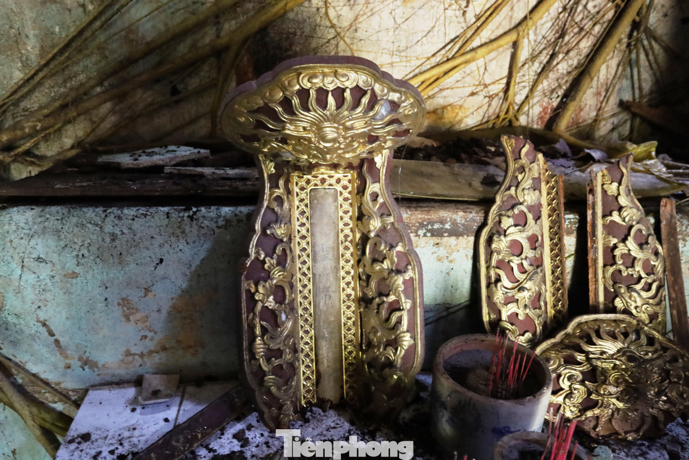 Những mảnh gỗ sơn son thếp vàng, vốn là những phần trang trí tinh xảo của bàn thờ, nay rơi rụng, nứt vỡ, nằm ngổn ngang như chứng tích của một thời huy hoàng đã xa. Chúng từng là biểu tượng của sự tôn nghiêm, gắn với những nghi lễ thiêng liêng xưa, nhưng giờ đây chỉ còn là những tàn dư lặng lẽ, phủ lấp bụi thời gian. Những mảnh gỗ sơn son thếp vàng, vốn là những phần trang trí tinh xảo của bàn thờ, nay rơi rụng, nứt vỡ, nằm ngổn ngang như chứng tích của một thời huy hoàng đã xa. Chúng từng là biểu tượng của sự tôn nghiêm, gắn với những nghi lễ thiêng liêng xưa, nhưng giờ đây chỉ còn là những tàn dư lặng lẽ, phủ lấp bụi thời gian.