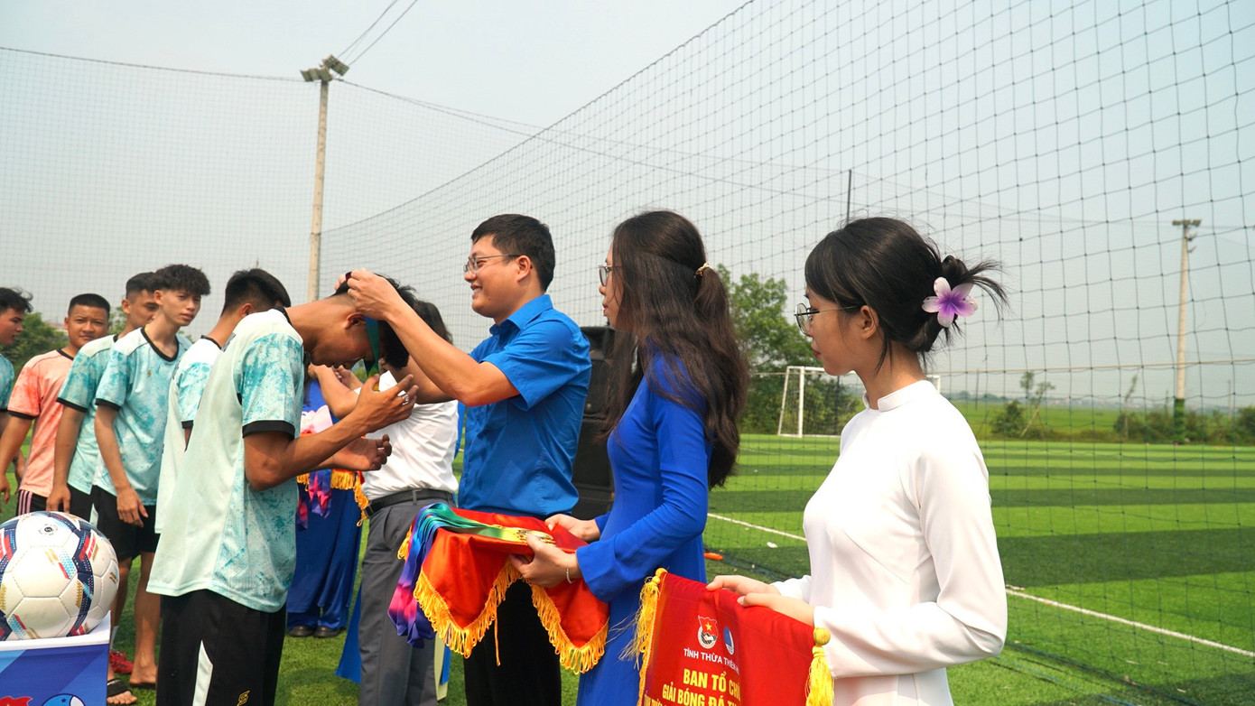 Trưởng ban tổ chức giải trao huy chương vàng cho thành viên đội đoạt cúp vô địch.