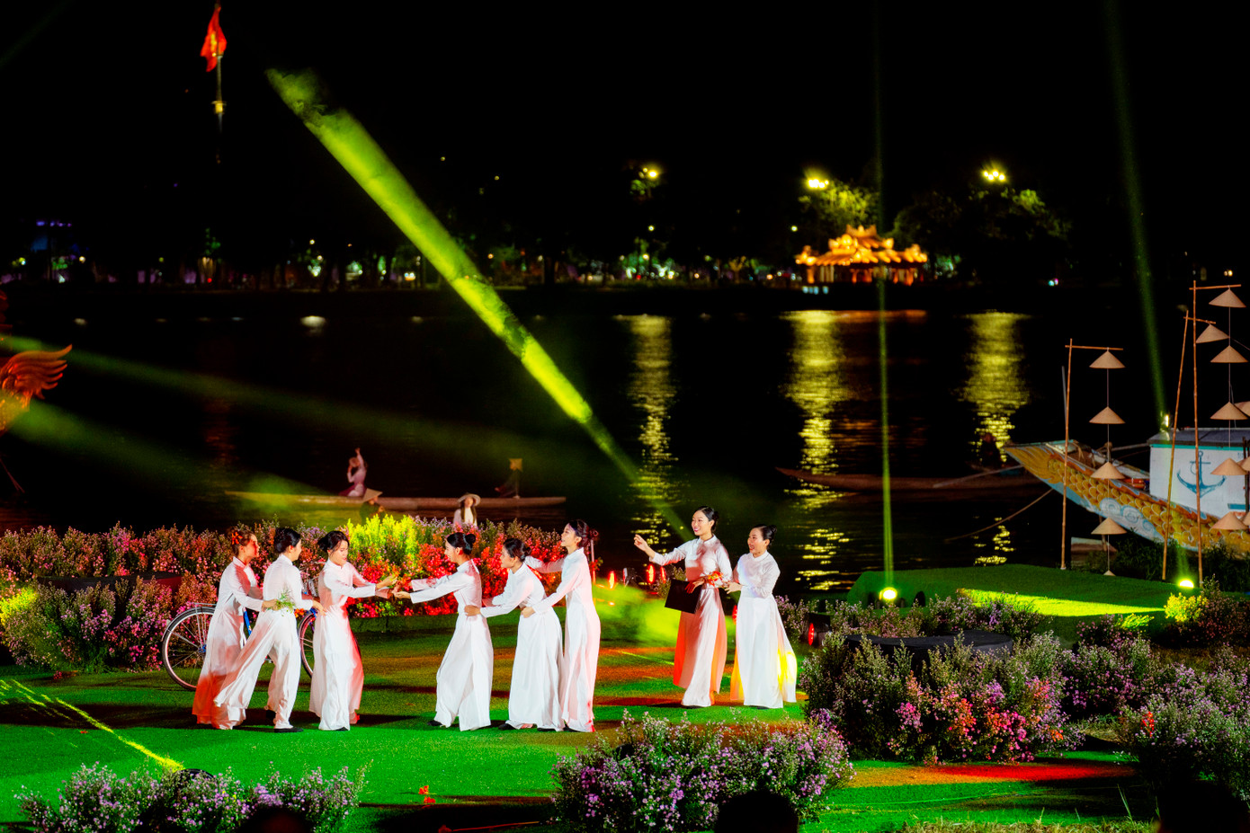 Địa điểm tổ chức đêm trình diễn áo dài Huế “Chuyện kể dòng sông” vào tối 12/8 cũng hết sức đặc biệt. Đó là bờ nam sông Hương đoạn cạnh Bia Quốc học, đối diện Kinh thành Huế. Một sân khấu mở ngay bên dòng sông Hương thơ mộng được kết hợp tinh tế từ những ảnh trên sông đến cảnh quang bên bờ. Âm thanh, ánh sáng đã được chuẩn bị để đem lại những hình ảnh ấn tượng nhất trong đêm diễn, giúp cho khán giả đến đây vừa xem trình diễn áo dài vừa có thể ngắm nhìn dòng sông Hương lung linh về đêm. (Ảnh: Đình Hoàng)