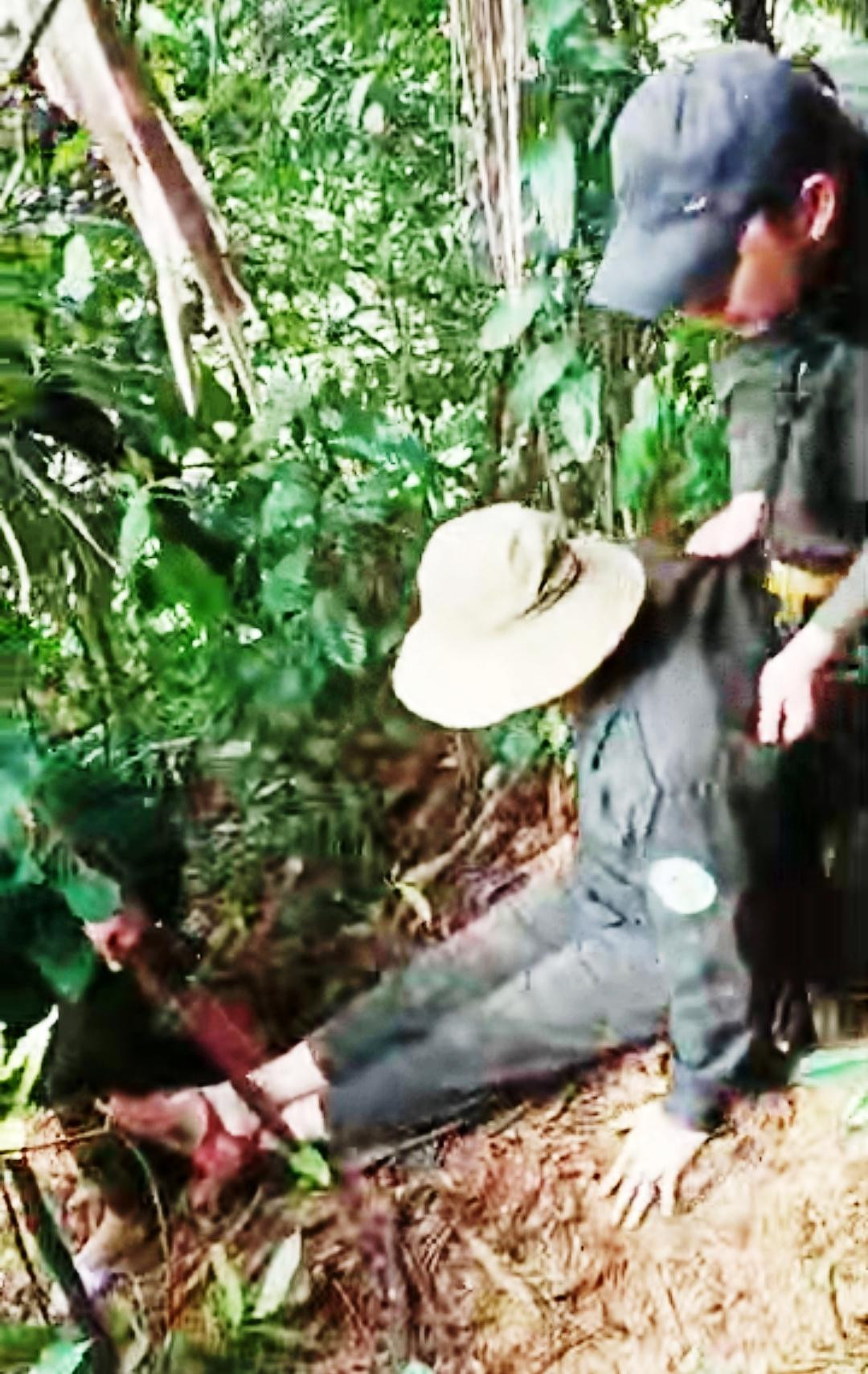 Ông Phú được đồng nghiệp hỗ trợ rời rừng sâu, dốc hiểm bằng hai tay (ảnh cắt từ clip).