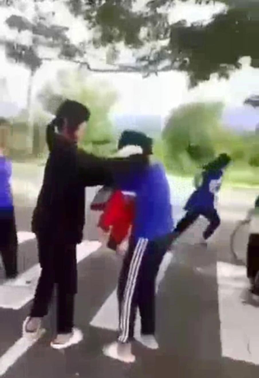 Nữ sinh L. (áo xanh) bị bạn nữ cùng trường hành hung. Ảnh cắt từ clip Nữ sinh L. (áo xanh) bị bạn nữ cùng trường hành hung. Ảnh cắt từ clip