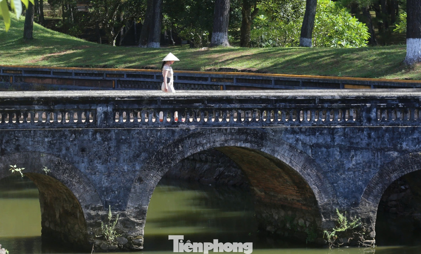 Du khách dạo bước trên một cây cầu đá nhuốm màu thời gian bên trong lăng vua Tự Đức.
