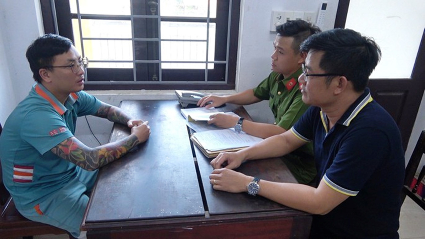 Đối tượng Nguyễn Đức Tài (bìa trái) tại cơ quan công an.