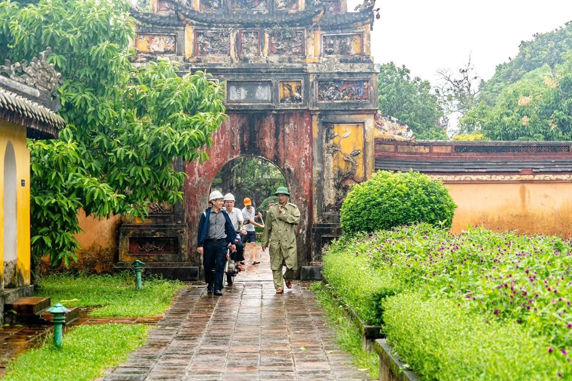 Ông Hoàng Việt Trung (bìa phải) - Giám đốc Trung tâm BTDTCĐ Huế - đi kiểm tra các công trình di tích tại Đại nội Huế sau bão. Ảnh: Bảo Minh
